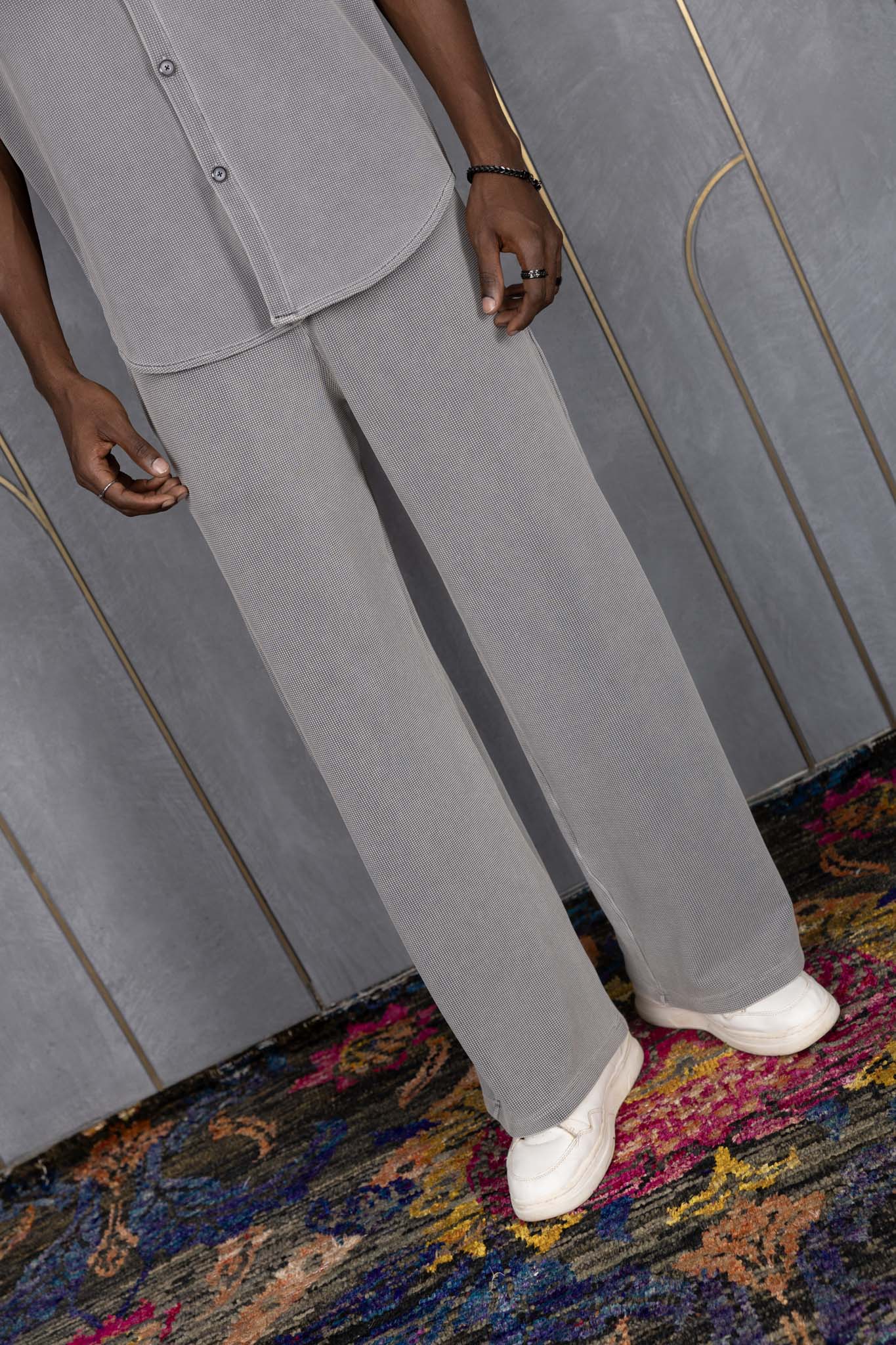 Person wearing ORE OFE's waffle bottom standing in front of a grey wall on a textured rug