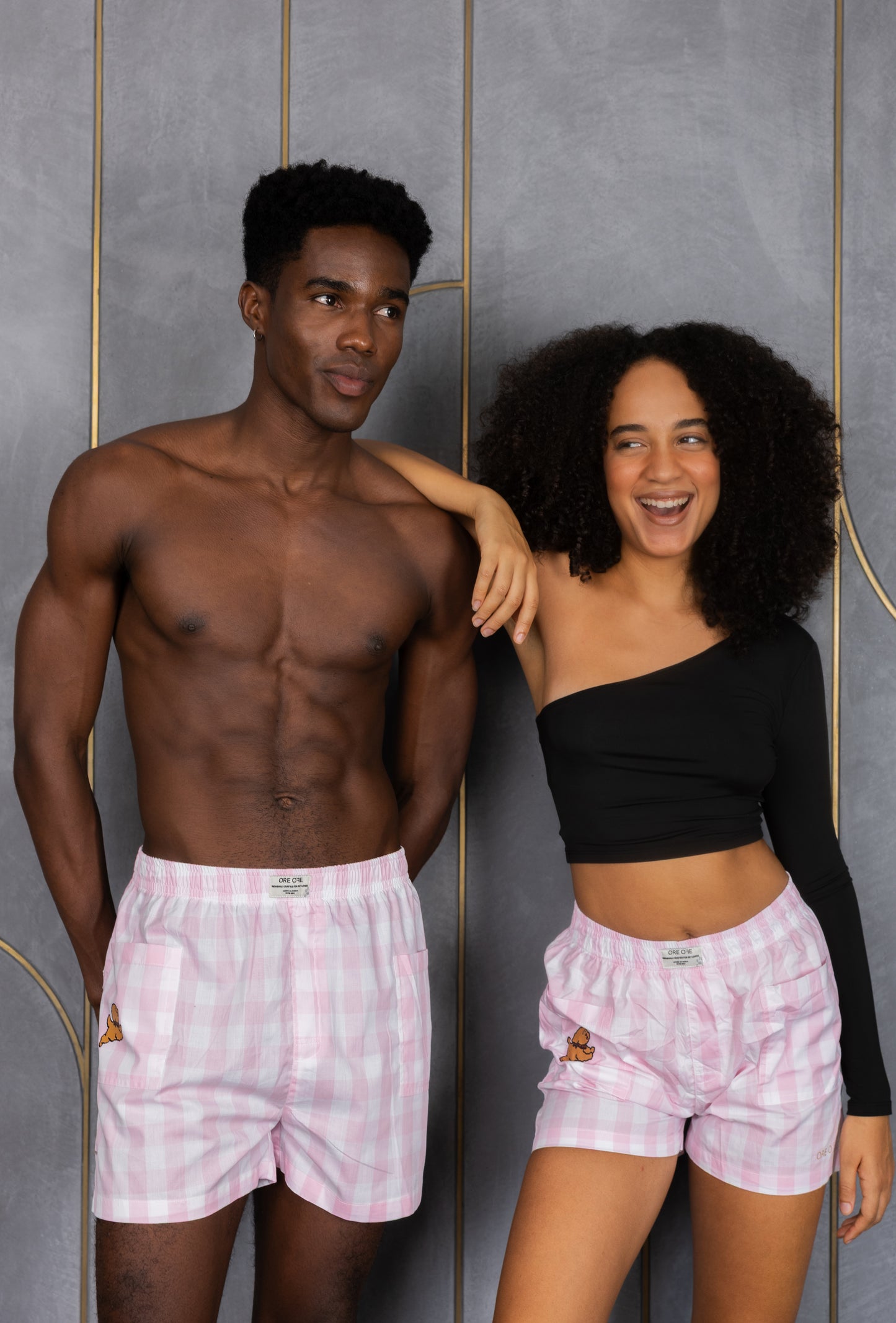 Two people wearing pink checkered boxers with a side pocket and a dog design