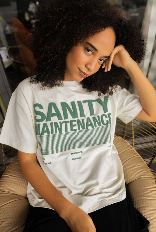 Person wearing a white t-shirt with 'SANITY MAINTENANCE' text in green.