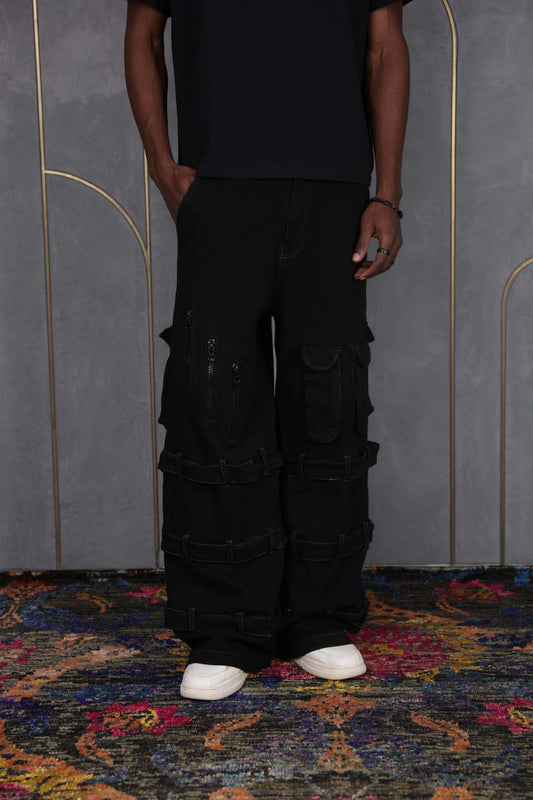 Person wearing ORE OFE's blackout vest & denim and standing in front of a grey wall on a textured rug
