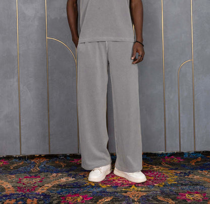 Person wearing ORE OFE's waffle tank & bottom standing in front of a grey wall on a textured rug