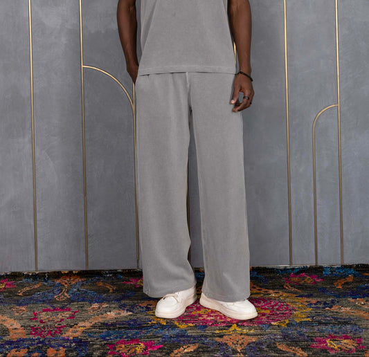Person wearing ORE OFE's waffle tank & bottom standing in front of a grey wall on a textured rug