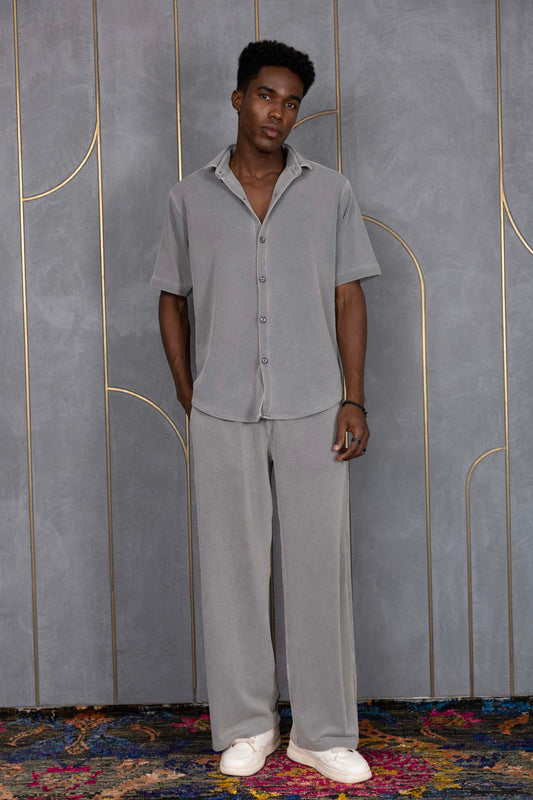 Person wearing ORE OFE's waffle shirt & bottom standing in front of a grey wall on a textured rug