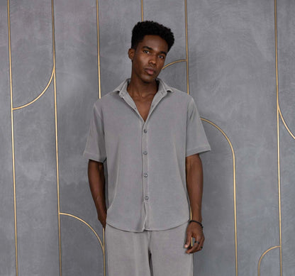 Person wearing ORE OFE's waffle shirt & bottom standing in front of a grey wall on a textured rug
