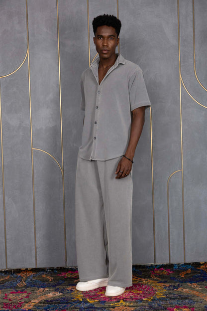 Person wearing ORE OFE's waffle shirt & bottom standing in front of a grey wall on a textured rug
