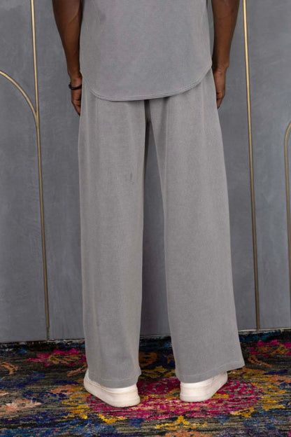 Person wearing ORE OFE's waffle shirt & bottom standing in front of a grey wall on a textured rug