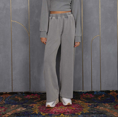 Woman wearing ORE OFE's grey waffle tank  & bottom standing in front of a grey wall on a textured rug