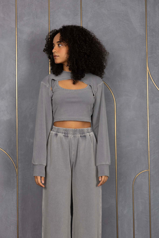 Woman wearing ORE OFE's grey waffle tank & bottom standing in front of a grey wall on a textured rug
