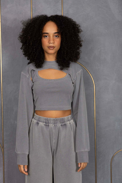 Woman wearing ORE OFE's grey waffle tank & bottom standing in front of a grey wall on a textured rug