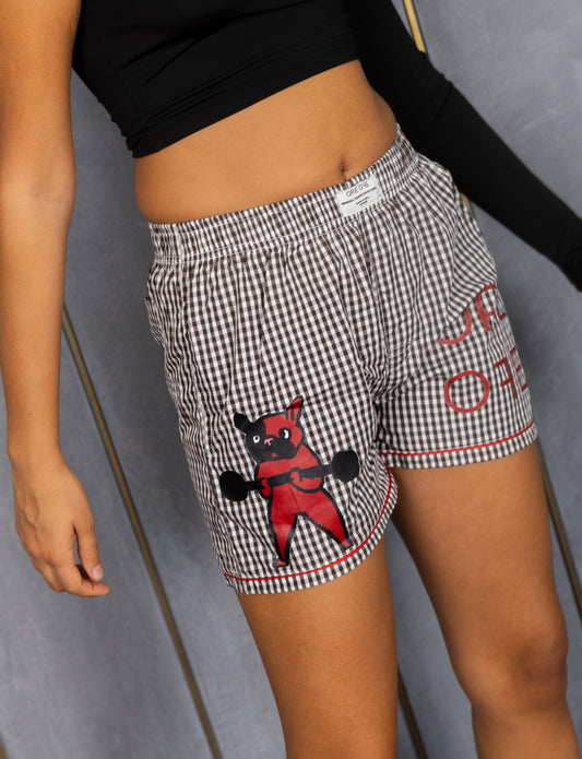 Model wearing white and black small checkered ORE OFE boxers with a dog lifting weights printed with ORE OFE logo