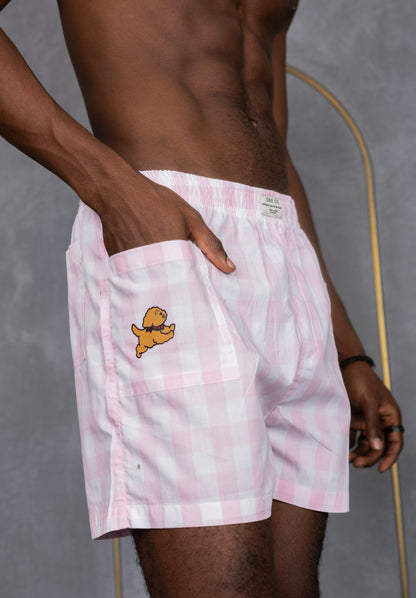 Model wearing pink checkered boxers with a side pocket and a dog design