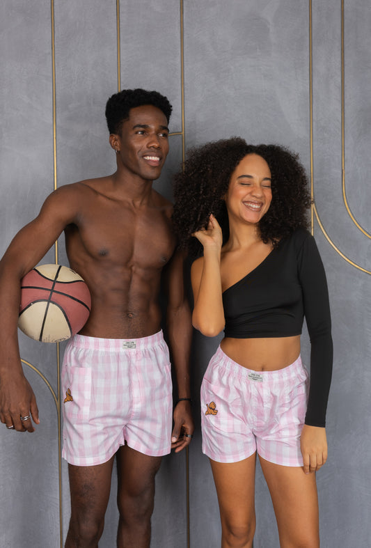 Two people wearing pink checkered boxers with a side pocket and a dog design