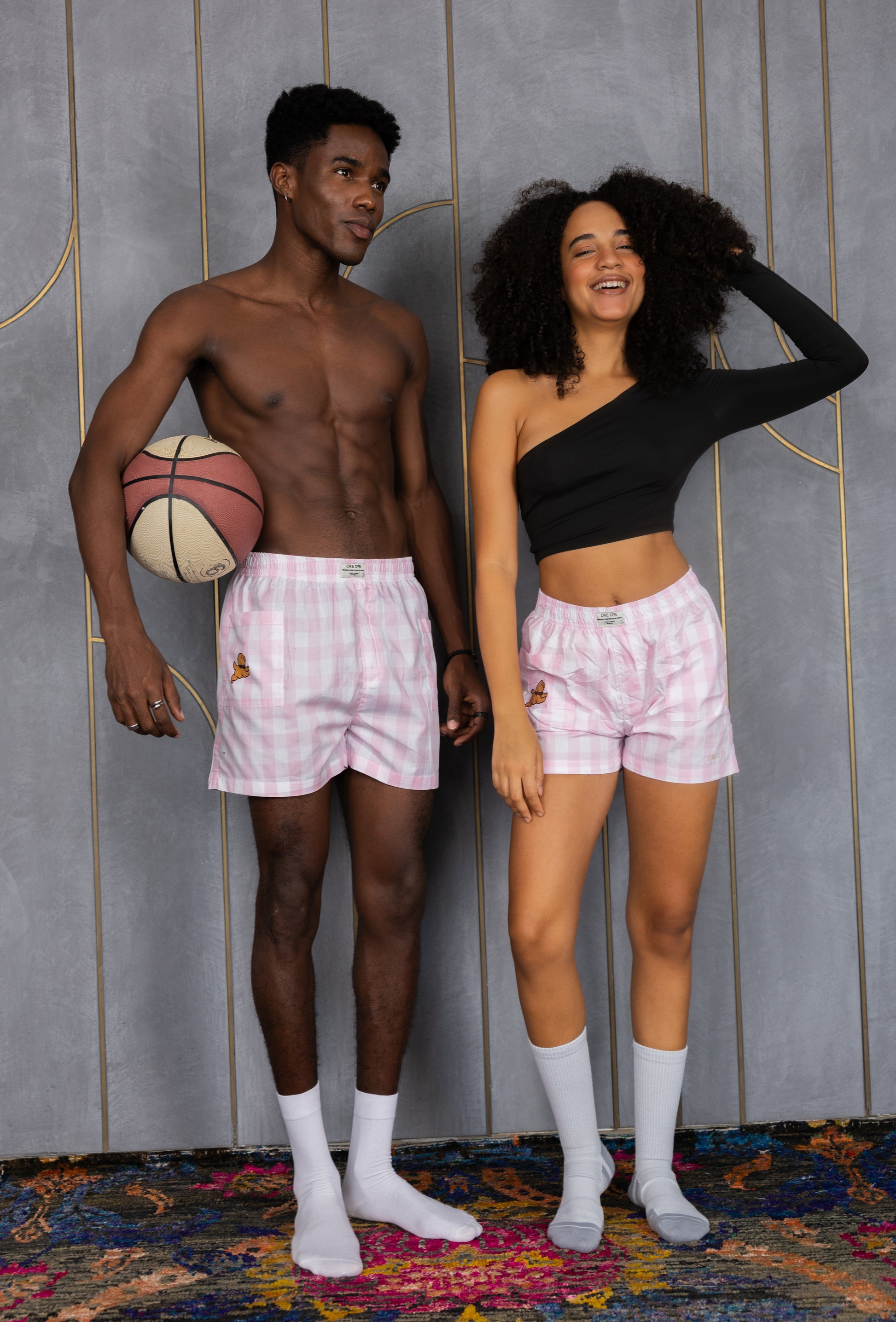 Two people wearing pink checkered boxers with a side pocket and a dog design