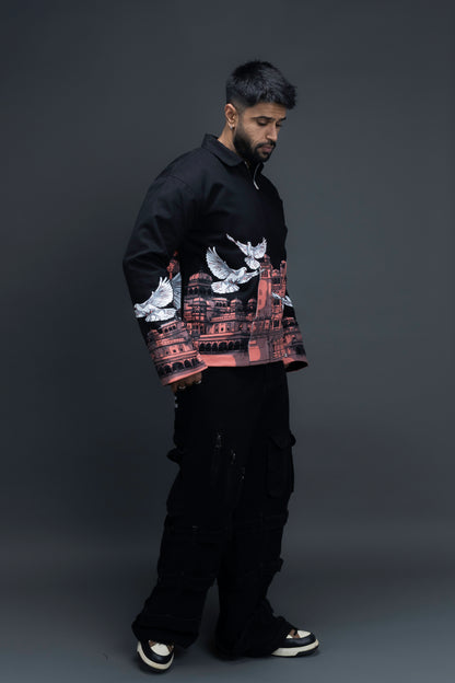 Man wearing ORE OFE's heritage black jacket that is designed on the theme of Hawa mahal standing against a grey background