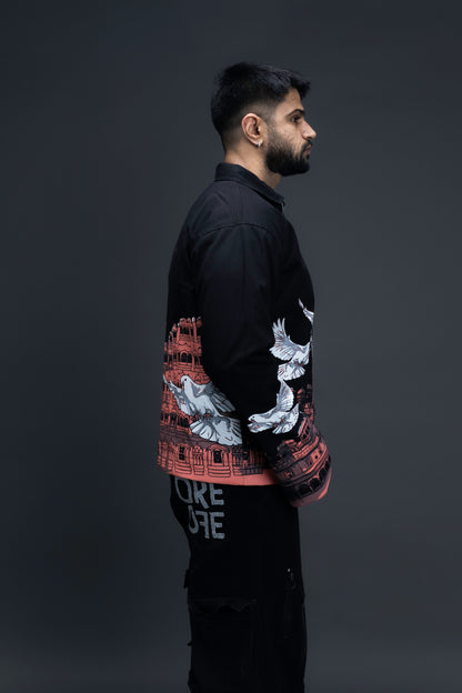 Man wearing ORE OFE's heritage black jacket that is designed on the theme of Hawa mahal standing against a grey background