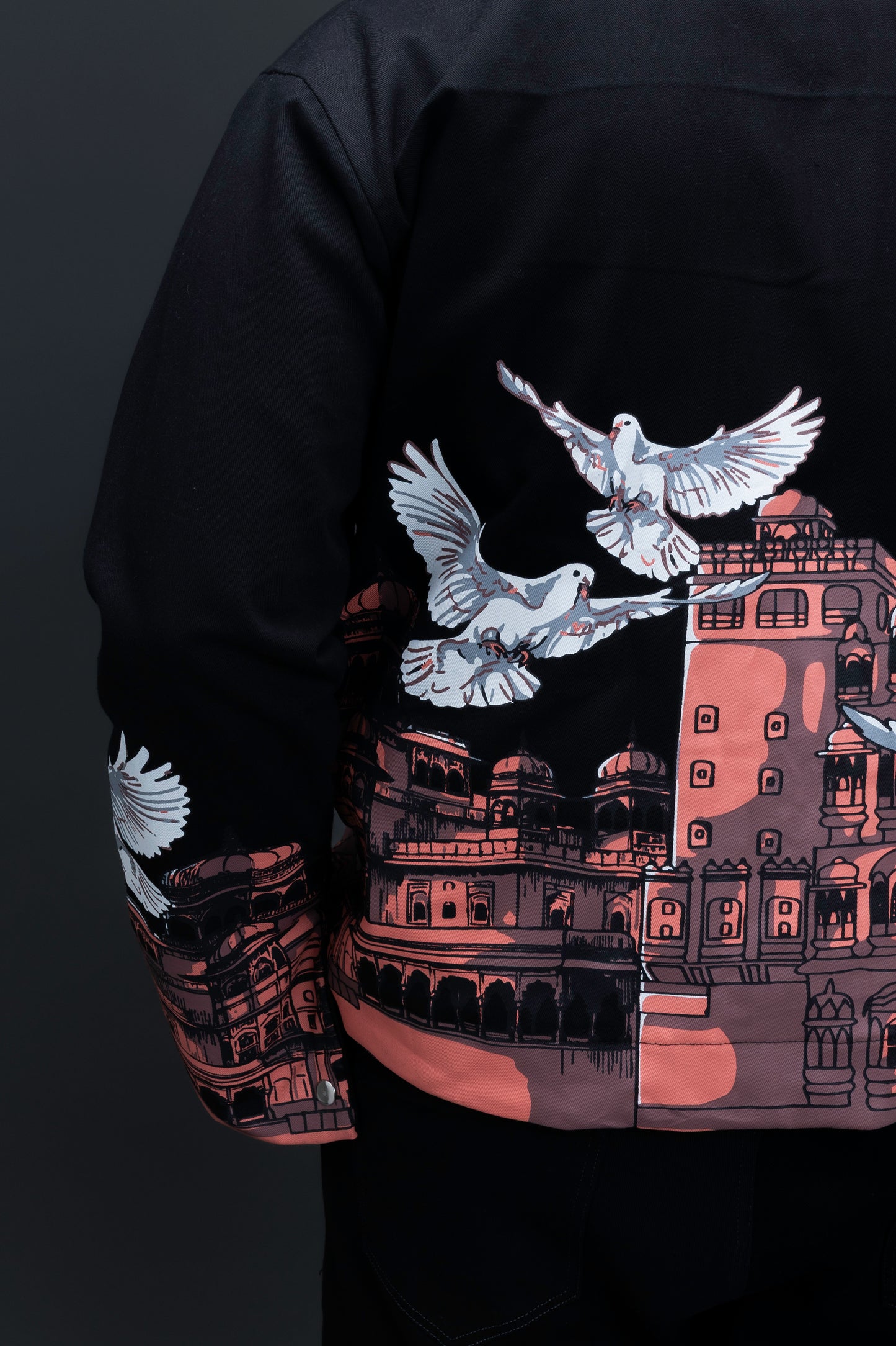 Man wearing ORE OFE's heritage black jacket that is designed on the theme of Hawa mahal standing against a grey background