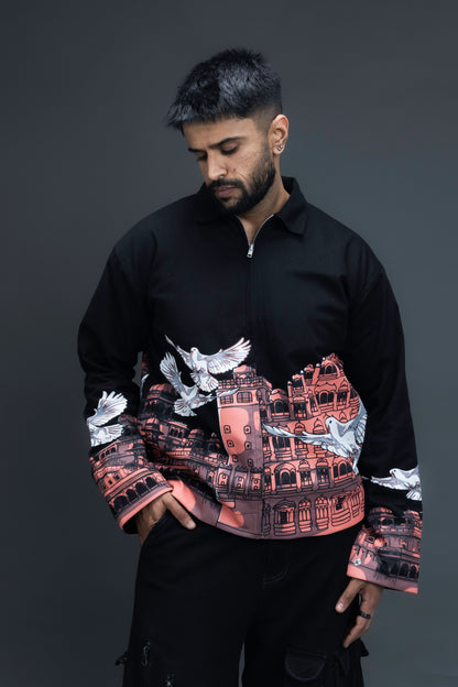 Man wearing ORE OFE's heritage black jacket that is designed on the theme of Hawa mahal standing against a grey background