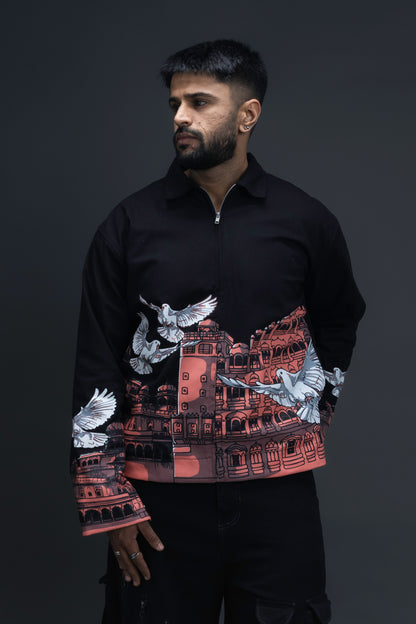 Man wearing ORE OFE's heritage black jacket that is designed on the theme of Hawa mahal standing against a grey background