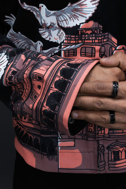 Man wearing ORE OFE's heritage black jacket that is designed on the theme of Hawa mahal standing against a grey background