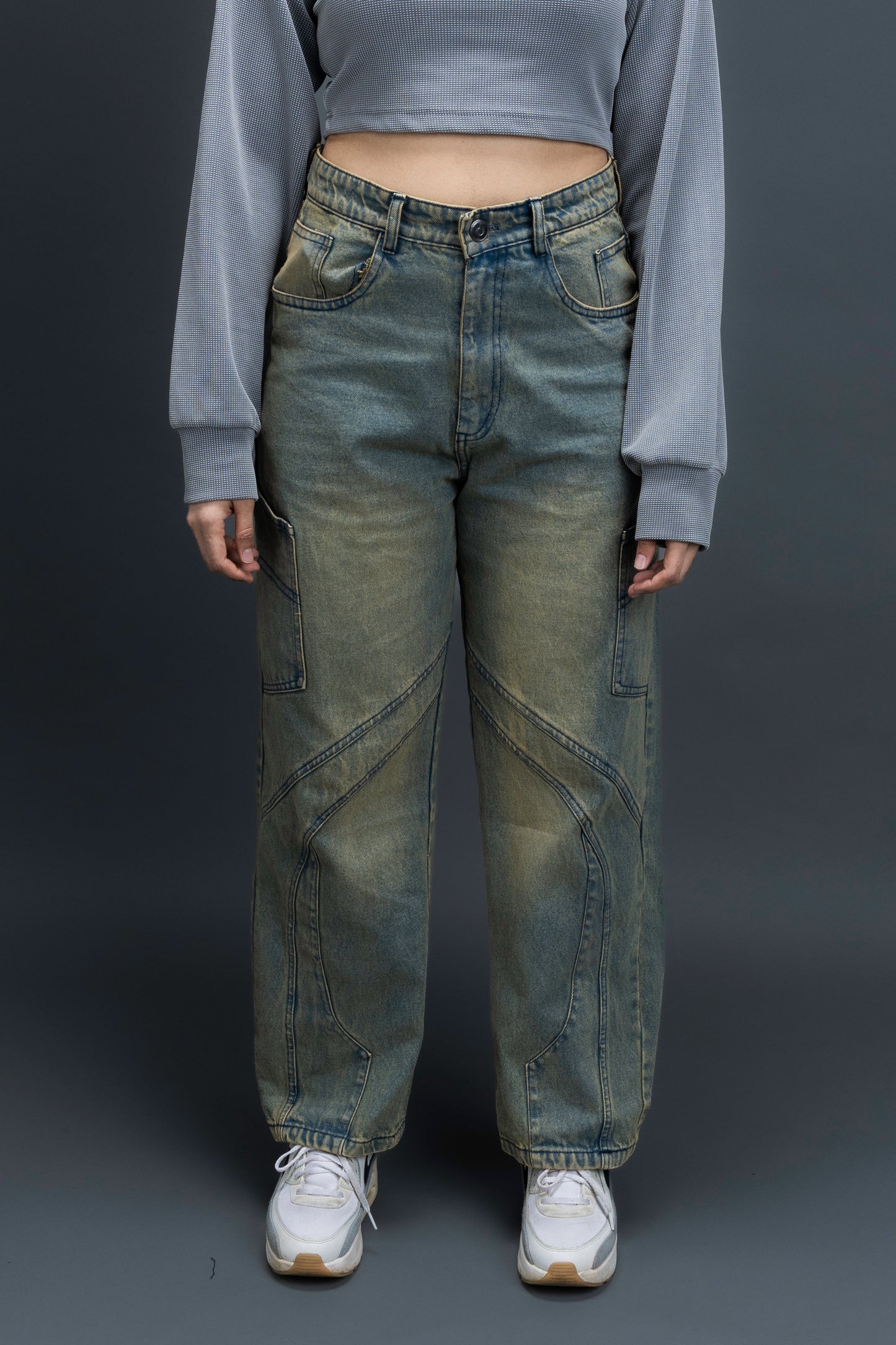 Person wearing ORE OFE's Vintage washed denim that has a pheonix embroided on the back pocket standing against a grey background