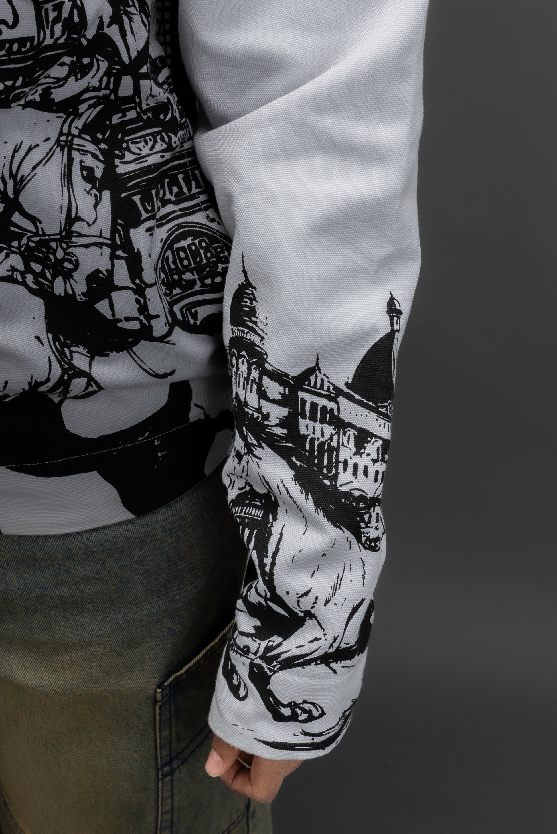 Person wearing a long-sleeve jacket with horse design on the sleeve.