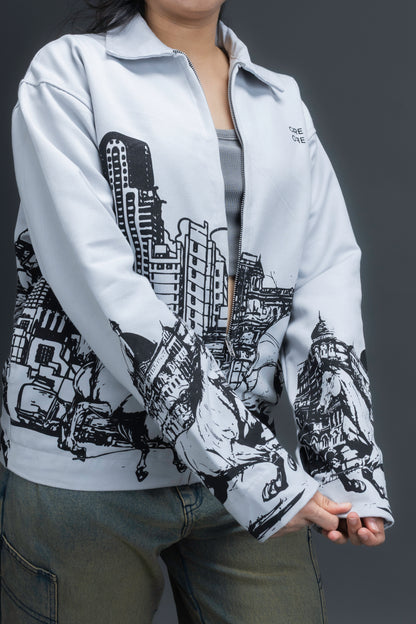 Women wearing a grey jacket with an upper-left chest logo and black cityscape graphic, standing against a dark background