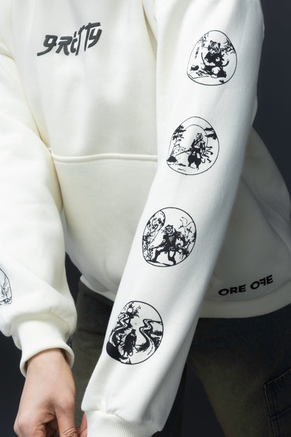 Person wearing a off-white contrast hoodie by ORE OFE with text on the chest that reads GRITTY & design on both sleeves, standing against a black background 