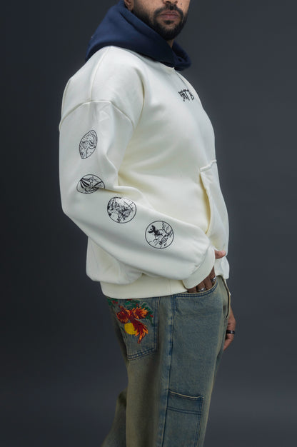 Person wearing a off-white contrast hoodie by ORE OFE with text on the chest that reads GRITTY & design on both sleeves, standing against a black background 