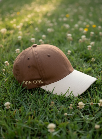 Brown and beige cap on grass with small flowers