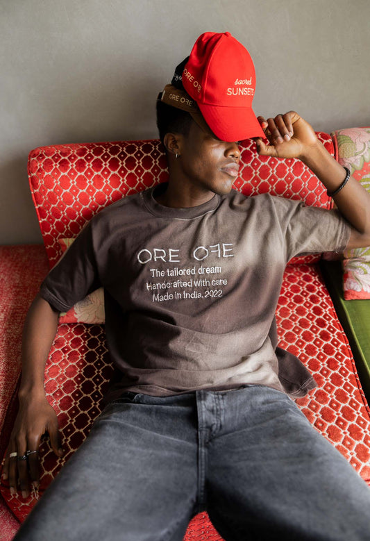 Person wearing a red cap and gray t-shirt lying on a patterned surface