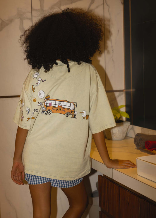 Person wearing a light-colored shirt with cartoon designs in a room.
