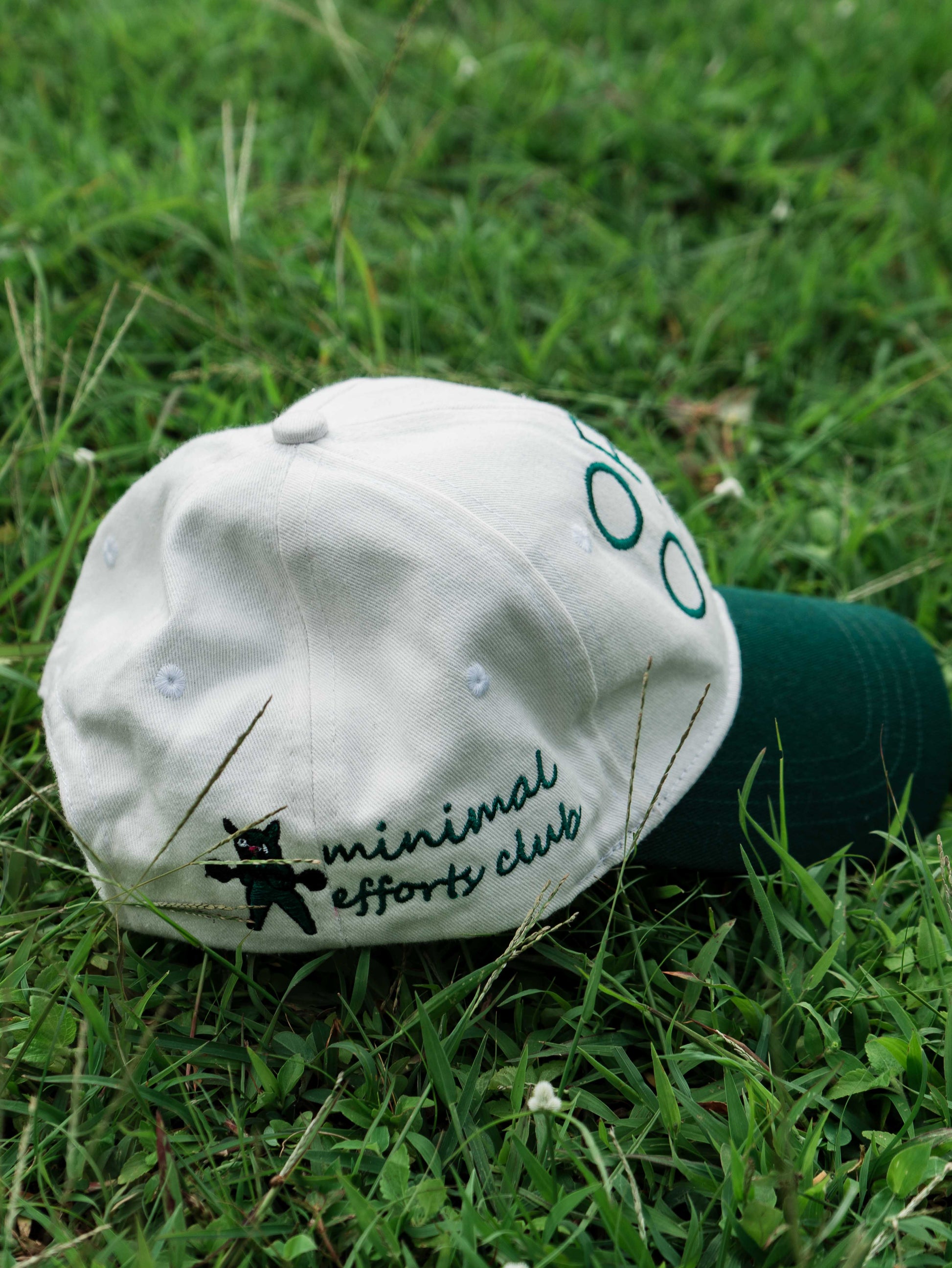 White & Green ORE OFE baseball cap with a design that reads minimal efforts club 