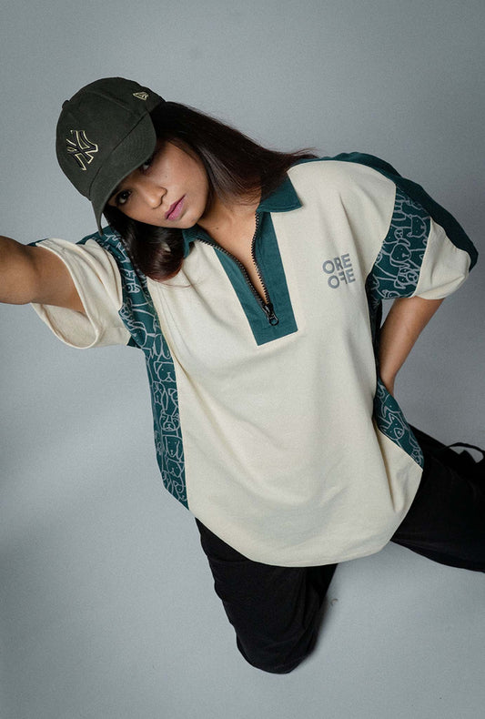 Person wearing a beige shirt with green cute dog print and a cap on a gray background