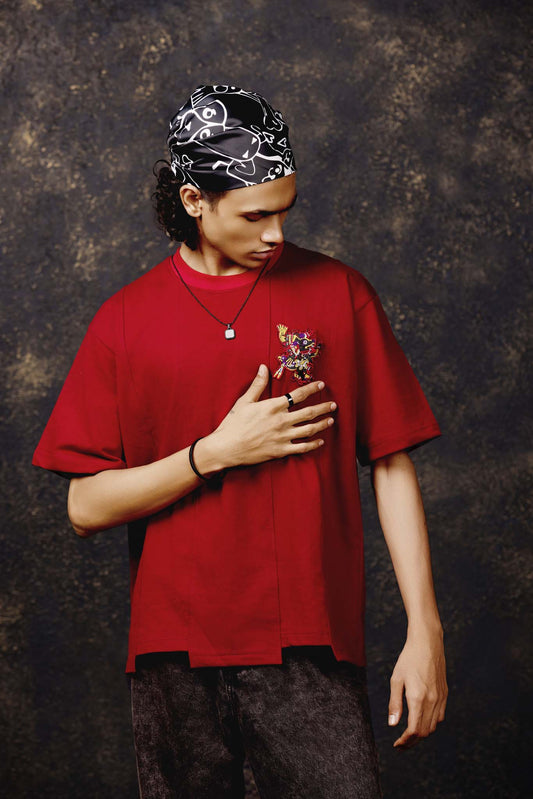 Person wearing a red shirt and black bandana against a textured brown background