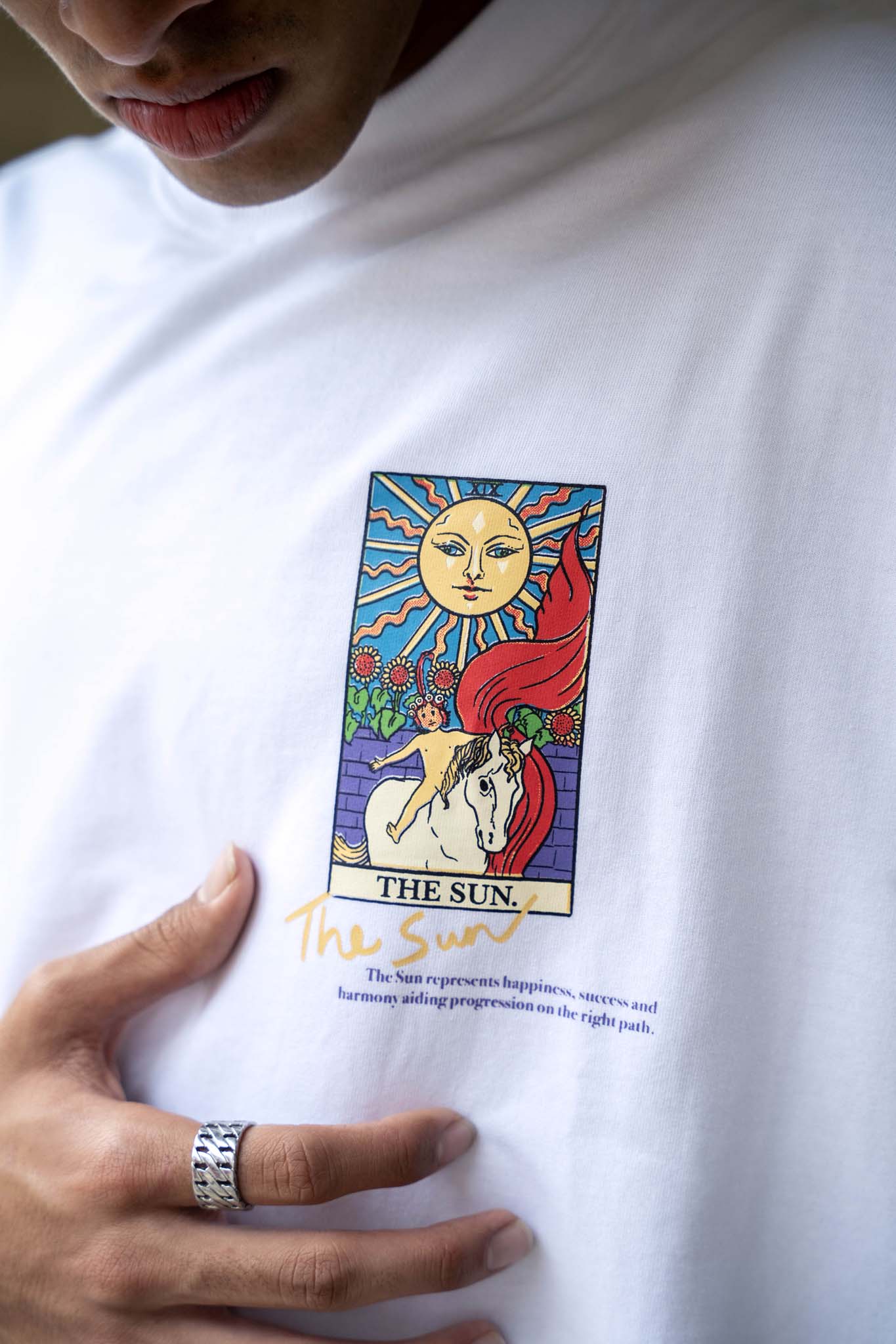 White t-shirt with 'The Sun' tarot card design worn by a person.