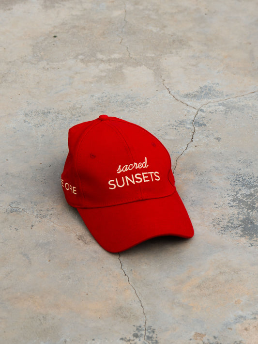 Red ORE OFE baseball cap with 'sacred SUNSETS' text 