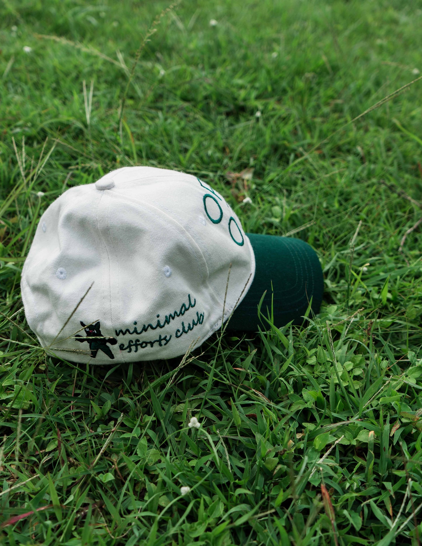 White & Green ORE OFE baseball cap with a design that reads minimal efforts club 