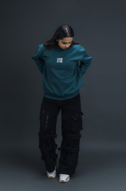 Person wearing a teal sweater with ORE OFE logo on the centre of the chest