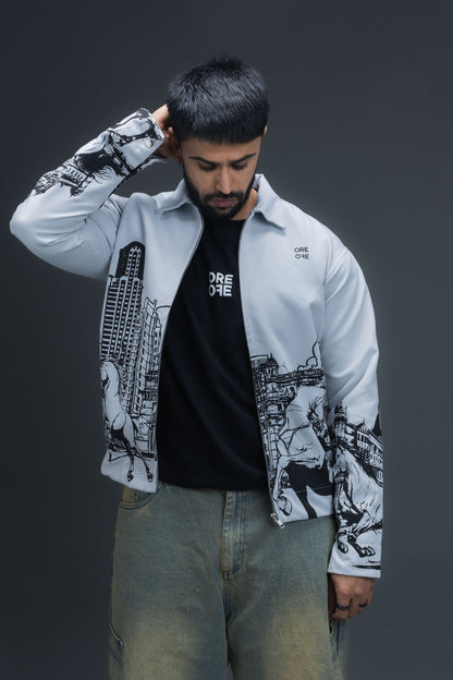 Person wearing ORE OFE's light grey jacket that has the Bombay skyline with horses printed on it standing against a dark grey background